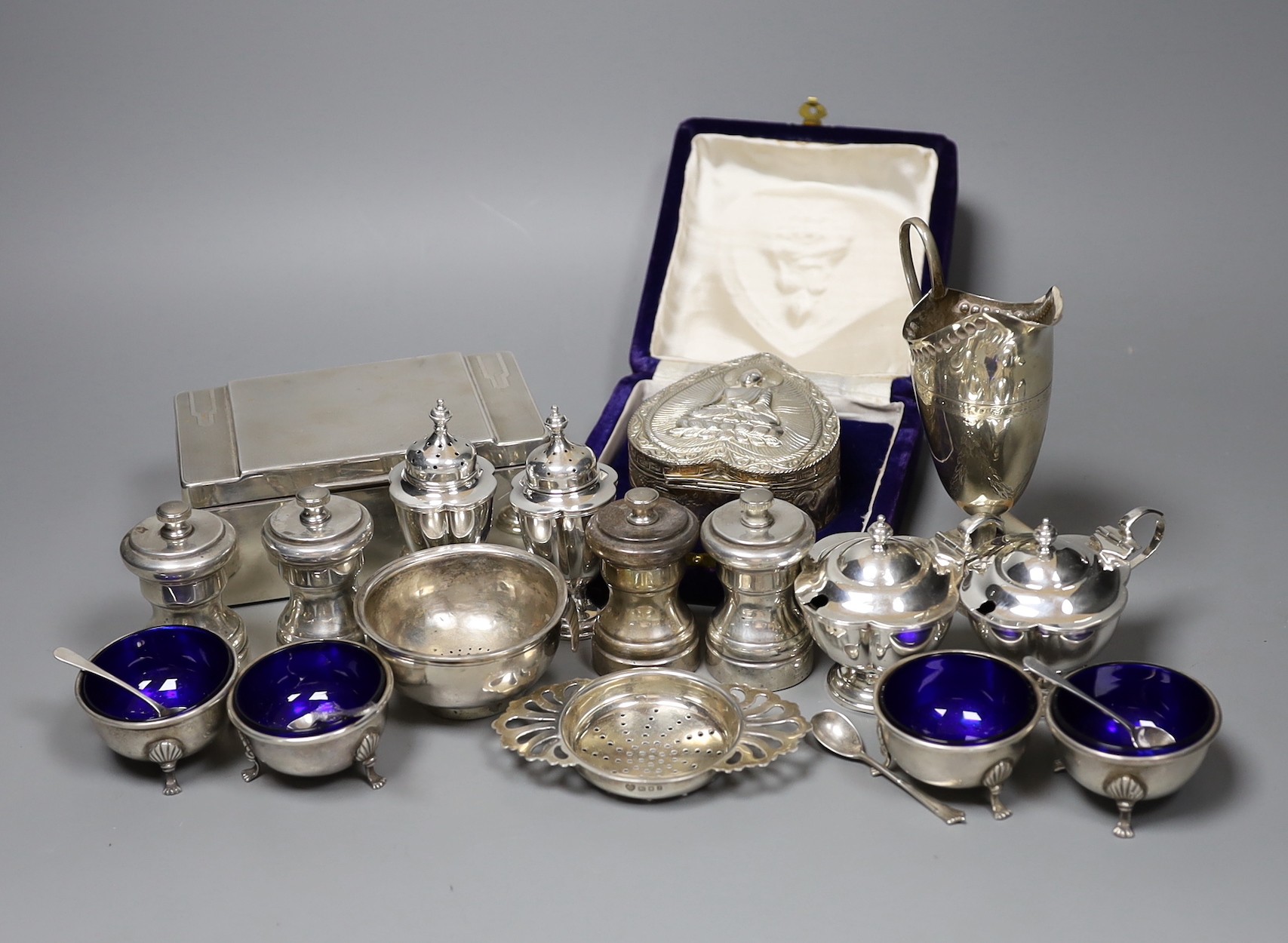 A Victorian engraved silver cream jug, Sheffield 1882, 13cm., engine-turned silver cigarette case, collection of pepper grinders, condiments, etc.